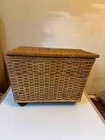 Front angle of wicker rolling basket showing woven texture and wheels beneath