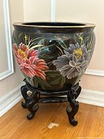 Front view of Chinese fish bowl planter on wooden stand showing floral design and gold rim