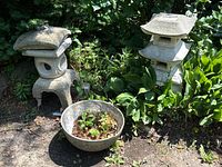 Overview of two pagoda lanterns and round planter bowl in garden