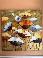 Front view of a square canvas floral painting with abstract flowers in orange, yellow, blue, and white colors on a green background.