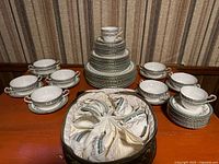 Full set of plates, bowls, cups, and saucers arranged on table