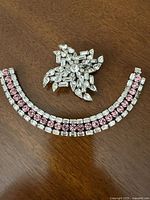 Photo of both the large Sherman clear rhinestone brooch and the pink and clear Austrian rhinestone bracelet showing overall condition and design.