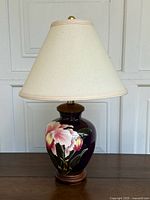 Full view of the vintage Asian style ceramic lamp on wooden base with beige fabric shade.