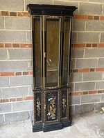 Full front view of the tall, slim black lacquered wooden display cabinet with glass door and hand painted Asian style decorations, showing its entire height and base design.