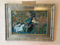 Framed vintage acrylic on silver foil painting featuring a traditionally dressed woman and three white ducks, framed in silver and gold with a mounted light fixture.