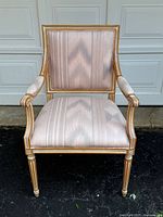 Front view of vintage French style armchair with light pink southwestern inspired upholstery showing wood frame and chair seat.