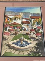 Close-up front view of the framed painting showing the vibrant scene with red umbrellas and fountain