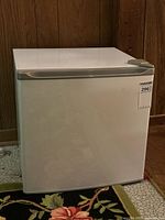 Closed view of white mini fridge showing clean exterior and simple handle design.