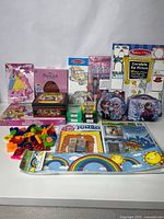 Wide view of children's activity materials including Disney Princess coloring books and stamps, Melissa & Doug activity books, Sesame Street puzzles, jumbo crayons, and foam letters.