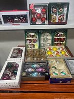 Image showing multiple boxes of assorted vintage and new glass Christmas ornaments neatly arranged on a shelf.