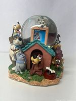 Front view showing multiple Disney dog figurines around the doghouse base and the Dalmatian inside the clear globe.