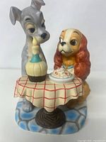 Front view of the Lady and the Tramp ceramic figurine showing the two dogs at the dining table.