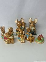 Image showing a group of 8 Pendelfin figurines including mice in various poses and costumes such as playing musical instruments and sitting on a green bed.