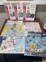 Full display of various scrapbooking sticker packs showing several brands and Disney character themes