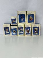 Group of nine Hallmark Keepsake Collector's Series boxed holiday ornaments, various festive and winter designs.