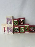 Front view of nine Hallmark Barbie Keepsake ornaments in original packaging, showing boxes with figurines and Christmas-themed designs.