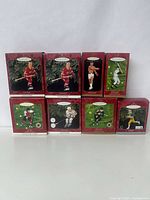 Eight Hallmark Keepsake sports-themed holiday ornaments boxed and arranged, showing variety of packaging and sport types.