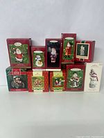 Photo showing entire set of ten Hallmark Keepsake ornaments in original, vintage boxes, including Santa Claus, snowman, and holiday scenes.