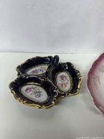 Photo of cobalt blue divided dish with three floral compartments and gold ornate edges.