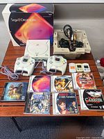 Lot overview showing console, box, controllers, memory cards, games, cables