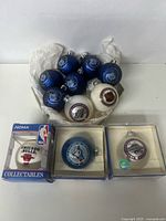 Blue and white round glass Christmas ornaments featuring Toronto Maple Leafs, Toronto Blades, NHL official logos, and boxed Toronto Blue Jays and Chicago Bulls NBA collectible ornaments.