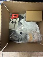 Box showing Makita 1/4 inch chuck key and wrapped parts