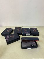 Five navy blue boxes of Laavoo hair extensions, one open showing extensions inside.