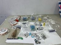 Wide shot of all the jewelry making items including beads, bead reamers, wire spools, and hardware laid out on table