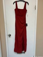 Front view of red Lulus dress hanging on black hanger showing full length, square neckline, and side slit