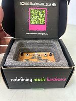 MIDI Blaster device inside box with foam padding and branding text with QR code on box inner flap