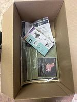 Box with items including umbrella box, origami kit, and packaged items