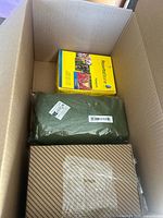 Contents of cardboard box showing Franklin Rosetta Stone language kit, green fabric item, and mesh screen