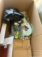 Box containing outdoor harness, packaged gloves, and some other items inside a cardboard box