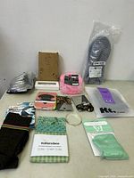 Overview photo of all items laid out on a table showing underwear pack, water shoes, socks, hair clips, scented sachet, reusable food wraps, and other accessories.