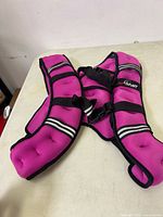 Purple weighted vest laid flat showing padded design, color and reflective stripes