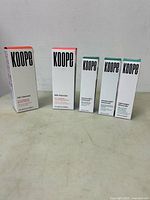 Five Koope skin care products standing side by side, showing front packaging and product names.