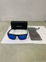 Full view of the Zenottic men's polarized sunglasses, black box, and gray drawstring pouch on a white background.