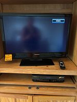 Magnavox 32-inch TV powered on with HDMI1 input showing, remote control on shelf to the right.