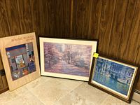 Three framed art prints placed on floor showing size and framing styles