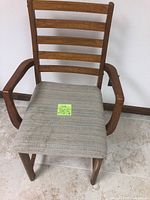 View of chair front showing ladder back and fabric seat with stains