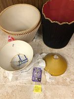 All lampshades and ceiling fixtures arranged on floor, showing relative sizes and colors