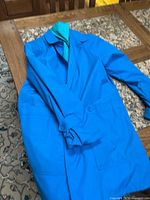 Blue London Fog jacket laid out showing classic lightweight design with collar detail and snap fasteners.