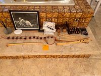 Wide view showing all wooden massage rollers, back scratchers, lotion applicator, a small framed art piece, and a package of 'TOEM' pads on tiled steps.