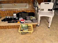 Photo showing shower chair, walker, back braces, ice packs, masks, bamboo charcoal packs in basket on floor