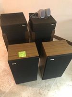 All speakers grouped: two Bose speakers in black ribbed front with wood side panels, two EPI speakers with wood veneer and black grille, two small gray Polk Audio mini speakers