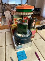 All tins stacked together on kitchen counter with label showing lot number and description