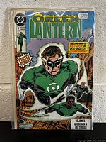 Photo of Green Lantern #1 comic book with colorful artwork and characters in superhero costumes. The comic is in protective sleeve with visible price sticker.