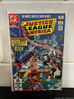 Front cover of Justice League of America #205 comic book showing detailed superhero battle scene and issue details including DC Comics logo, cover price 60 cents, and issue number.