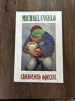 Front cover of the comic book titled 'Michaelangelo Christmas Special' with illustrated turtle character in winter clothing holding a kitten.