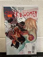 Front cover of Spider-Women Alpha comic book featuring Spider-Woman, Spider-Gwen, and Silk, showing near mint condition and protective sleeve.